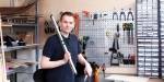 Bildet viser Lars med verktøy på OsloMet Makerspace. Han har vater og tang i hendene, og på veggen bak er det forskjellig verktøy og skruer.