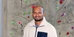 Faisal in front of the on-campus climbing wall.