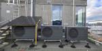 Three heat pumps next to each other outdoors.