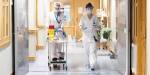 Two nursing home employees wearing face masks and visors.