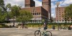 Man on a bike in front of Oslo City Hall.