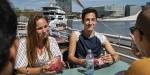 A man and a woman eating at an outdoor cafe next to the fjord.