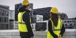 Masterstudenter i energi og miljø i bygg – sivilingeniør står på operataket i Oslo med gule hjelmer og refleksvester og peker mot Barcode.