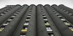 Dark grey and tall silo tuned into student housing with window rows on each column.