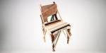 A chair made from components of different chairs, of various colours and types of wood.