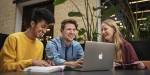 Samfunnsernæring-studenter sitter ved et bord med lærebøker og en laptop.