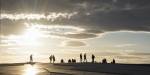 Silhouettes of people walking on the opera roof and the sun behind a cloud creating beautiful light.