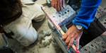 Hands of a constructor working with bricks