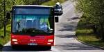 Rød buss på landevei i Norge.