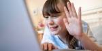 young girl looking into screen raising hand