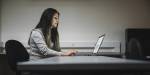 Woman sitting in front of a computer typing