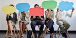 Five people sitting on chairs, holding up colourful speech bubbles. Photo: Colourbox