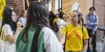 En smilende student med gul OsloMet-t-skjorte blant mange andre studenter.