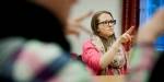 Ung kvinne bruker tegnspråk i undervisningssammenheng i klasserom.