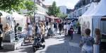 Personer går i en gågate i Lillestrøm sentrum. Det er en solfylt sommerdag.