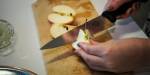 Eple som blir skore opp på skjerefjøl med ein stor kniv.