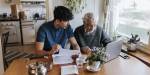 A son helps his old father pay bills online
