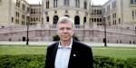 portrettbilde av tidlegare statsminister Kjell Magne Bondevik, foran Stortinget