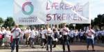 Fagforening protesterer med plakater på gata