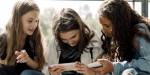 Young girls looking at mobile phones