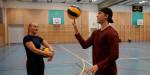 Åsne ser på Mats som trikser med en ball.