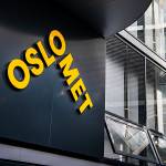 OsloMet-logo på svart fassade med vinduer.