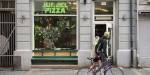 A couple with a bike walk by the entrance to Jungel Pizza. Photo: Benjamin A. Ward