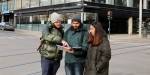 Markus, Asim og Amna studerer kart ved eit vegkryss i Oslo.