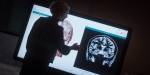 Anita peker på en stor skjerm med et CT-bilde av en hjerne.