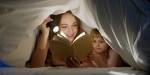 Illustrasjonsbilde av voksen kvinne og liten jente som gjemmer seg under en dyne og leser en bok i lyset fra en lommelykt.