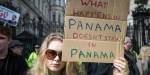 Kvinne protesterer i London med et pappskilt der det står: "What happens in Panama doesn't stay in Panama".