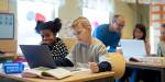 Elever i klasserom leser og arbeider med PC og bøker.