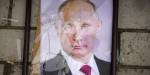 Et portrettbilde av Putin i glass og ramme som ligger knust på bakken
