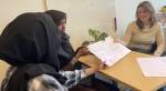 Tre personer rundt et bord med grønn plante, holder fram en plakat de har skrevet selv