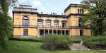 Fasaden til vitenskapsakademiets villa i Oslo, bygd i herskapelig arkitektur, malt i gult, med stor hage.