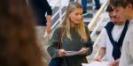 Ungdommer diskuterer sammen ved å se på papirer i en skoletrapp.