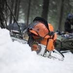 Motorsag på snø av merket "Stihl" og hjelm