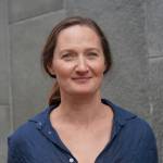 Portrait of a woman in front of a grey concrete wall.