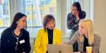 Women sitting together, testing software on a laptop.