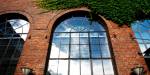 a facade of one of OsloMet's buildings, characterised by a curved window on a brick wall.