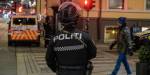 Uniformert politi og politibiler i mørk gate