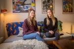 Kristine og Oda sitter i sofaen i leiligheten sin i København.