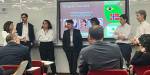 Researcher Karine Maria Porpino Viana beside colleagues from Norway and Brazil in front of a presentation in Brazil