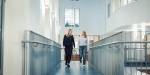 oversiktsbilde av Jennifer og Anette som går i en korridor på campus.