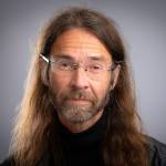 Portrettbilde av forsker Arne Holm som ser i kamera og smiler.