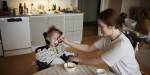 Mother feeding child at kitchen table