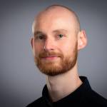 Portrettbilde av forsker Nils Arne Lindaas som ser i kamera og smiler.