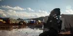 Child blowing bubbles in a muddy refugee camp, with tents and makeshift shelters in the background under a partly cloudy sky.