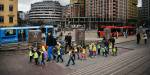 En gruppe barnehagebarn med voksne går på rekke og rad på Jernbanetorget i Oslo.