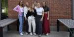 Gruppebilde av barnehagelærerstudenter foran en murvegg på studiested Pilestredet